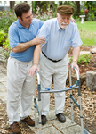 man helping senior walk with assistive device