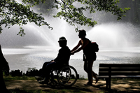 worker pushing man in wheelchair