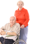 Elderly woman is with her elderly husband who is in a wheelchair